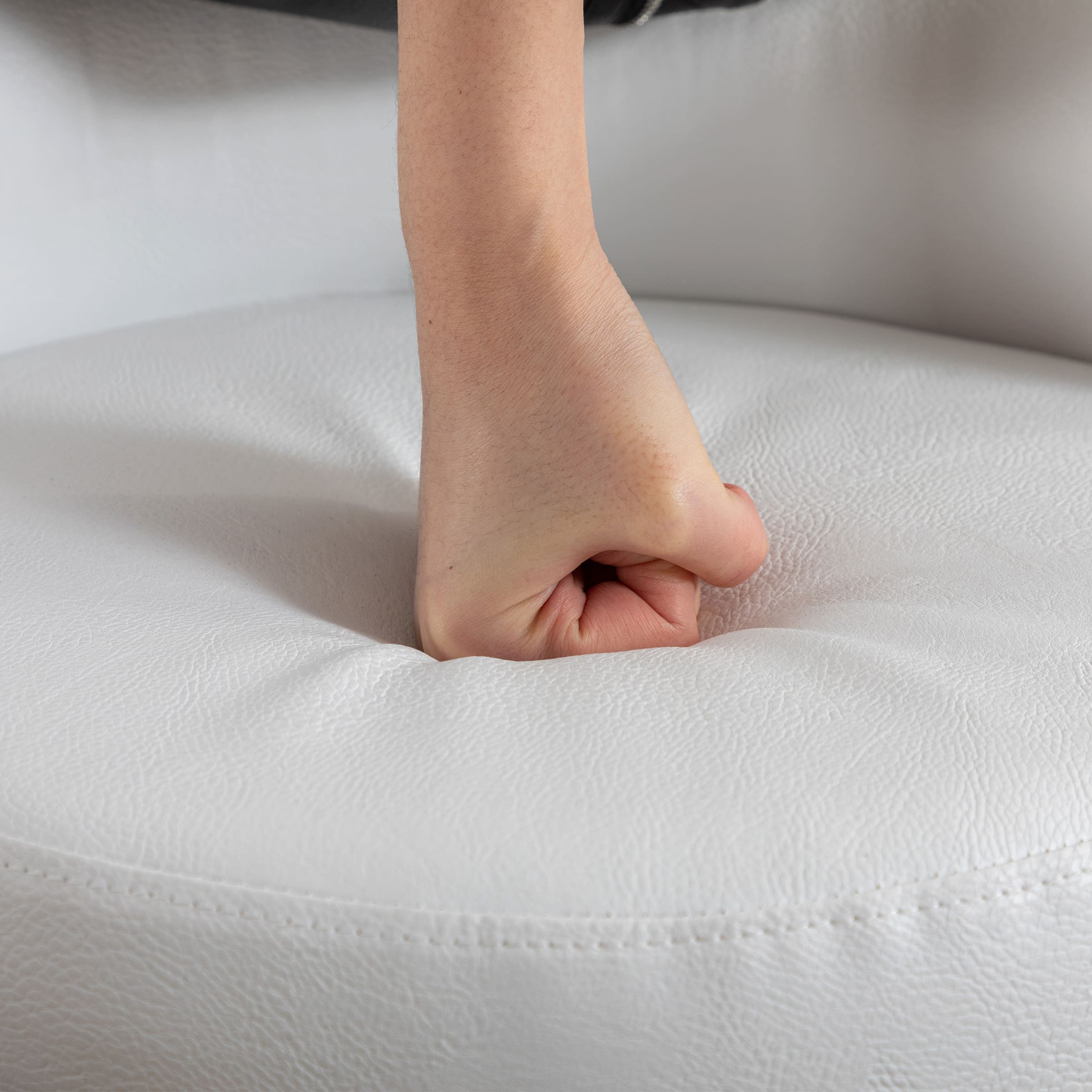 Hand pressing into white seat cushion