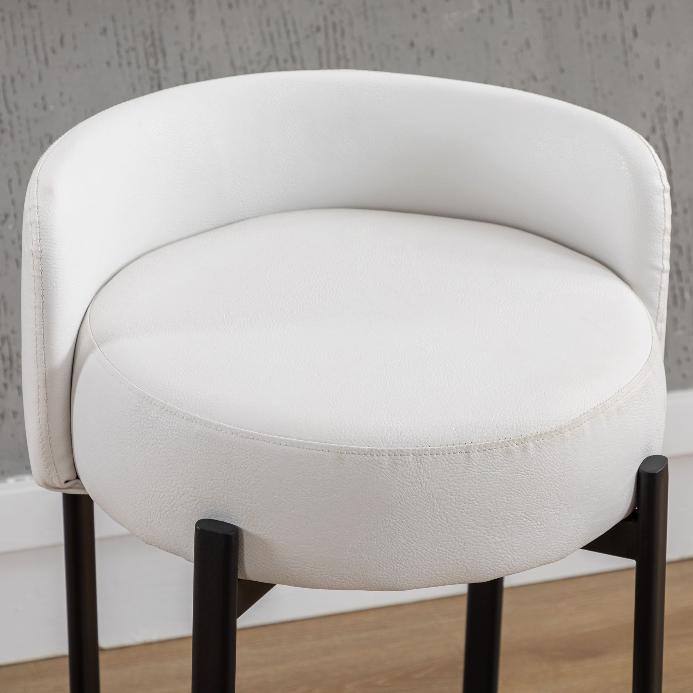 Close-up of white circular seat cushion and white upholstery