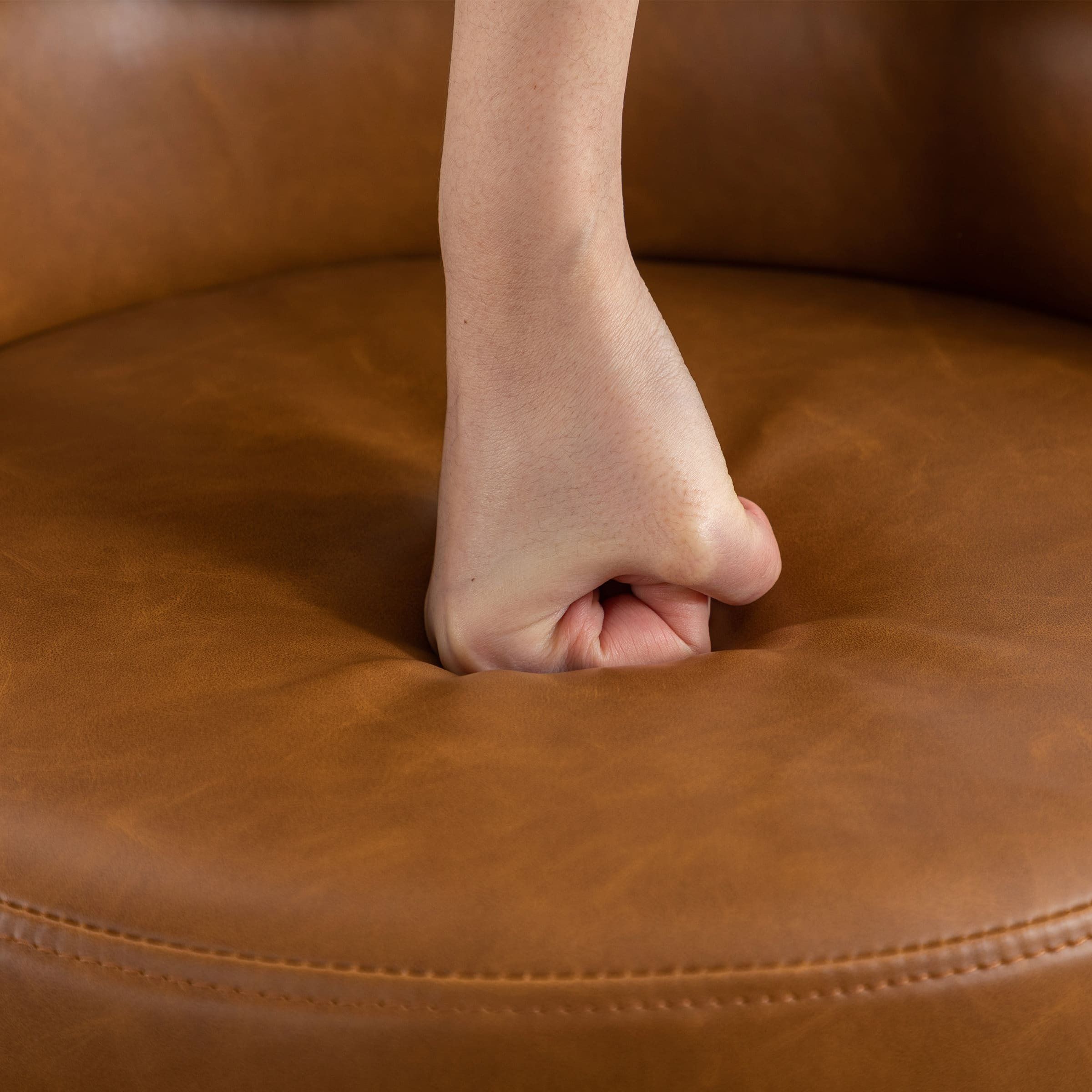 Finger press into tan cushion showing softness