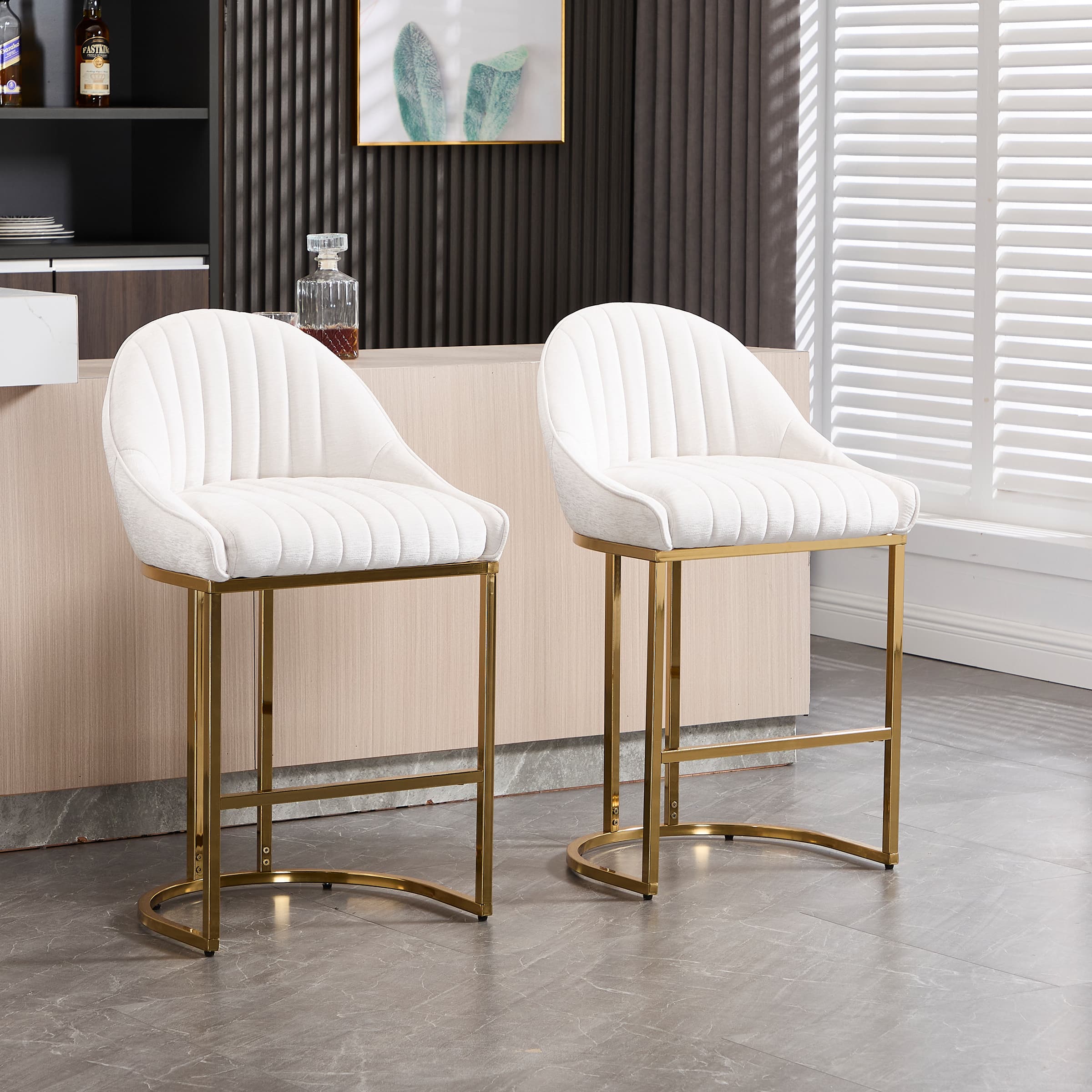 Two white upholstered bar stools with gold metal legs