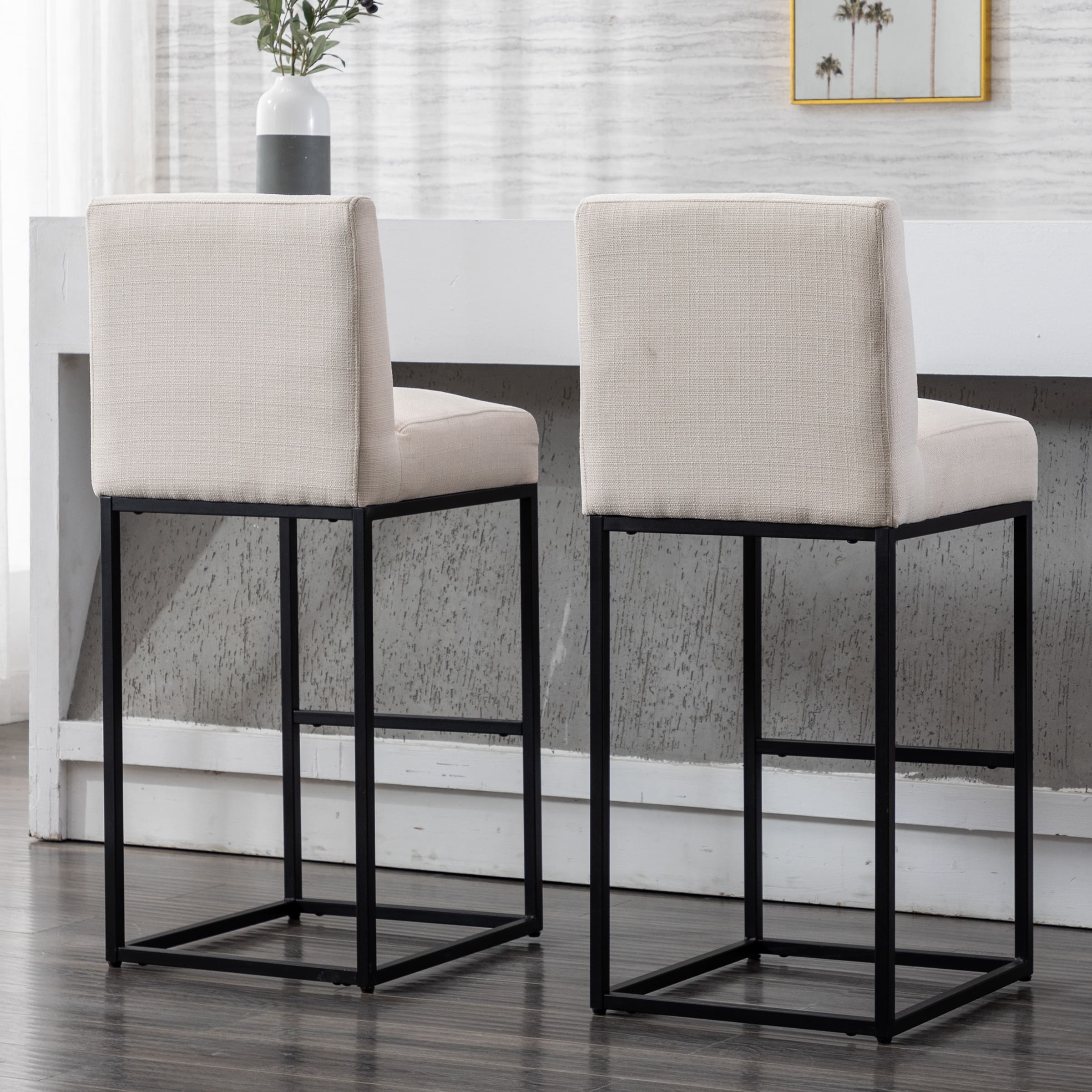 Two beige stools with white backs and black frames