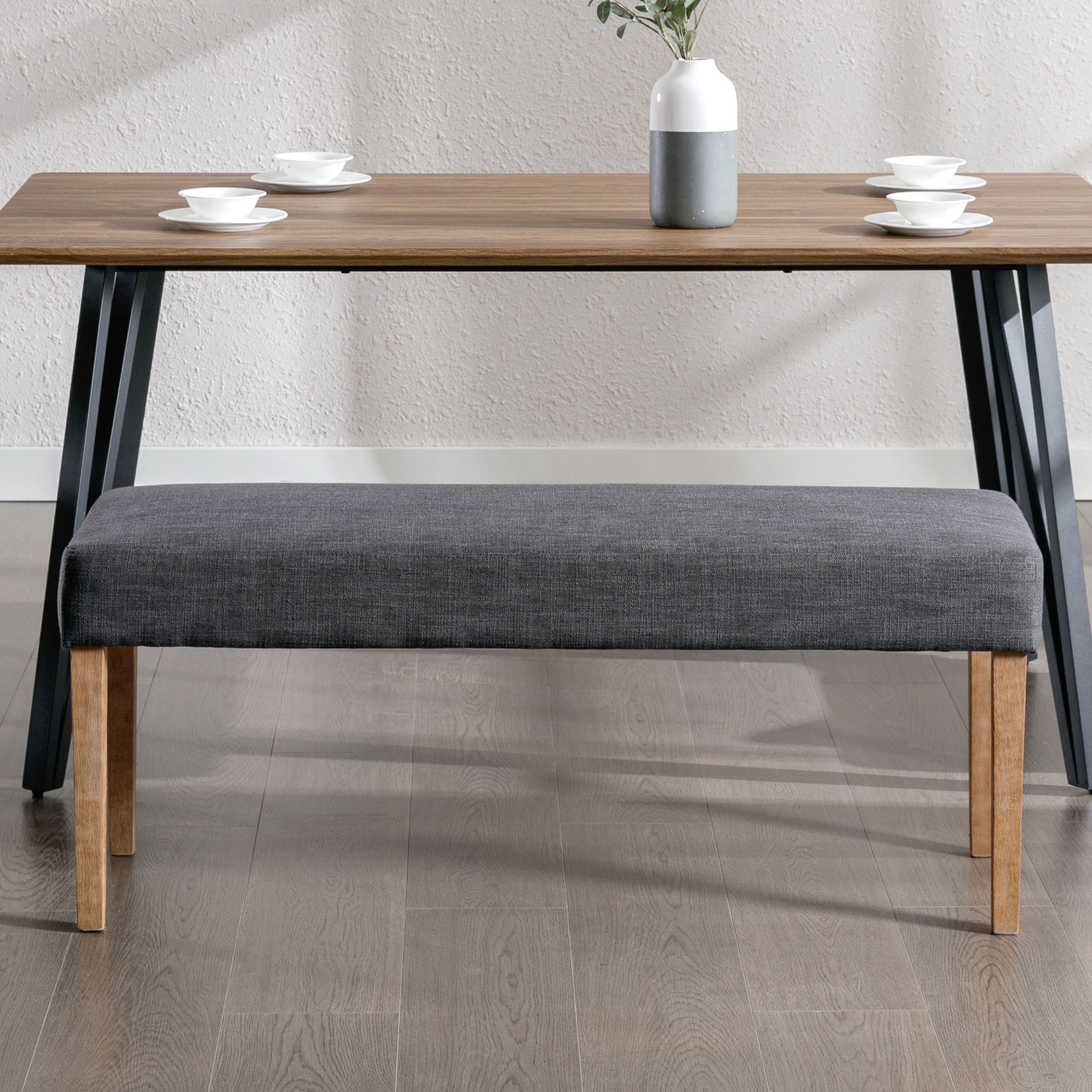 Bench with grey upholstery and wooden legs