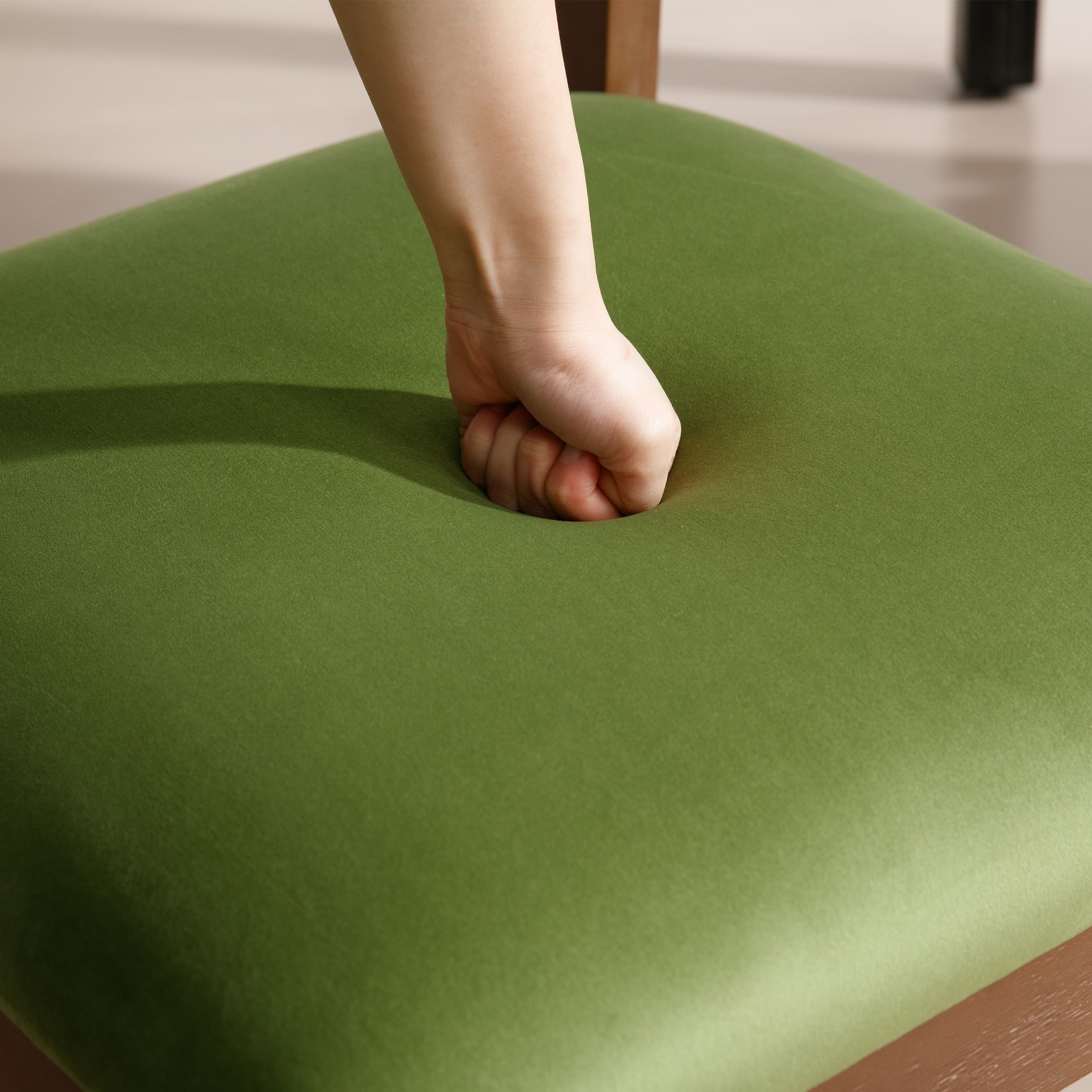 Hand pressing into chair seat cushion
