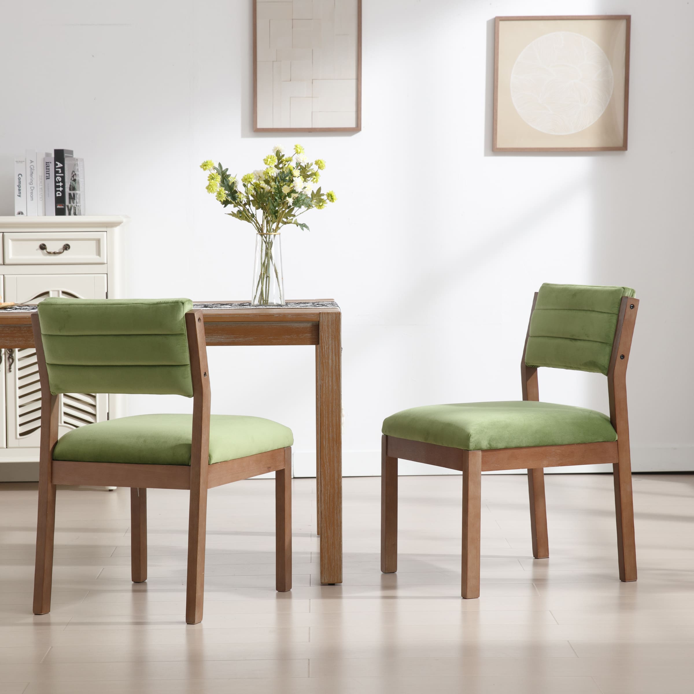 Two green upholstered dining chairs with wooden frames seen from front and side