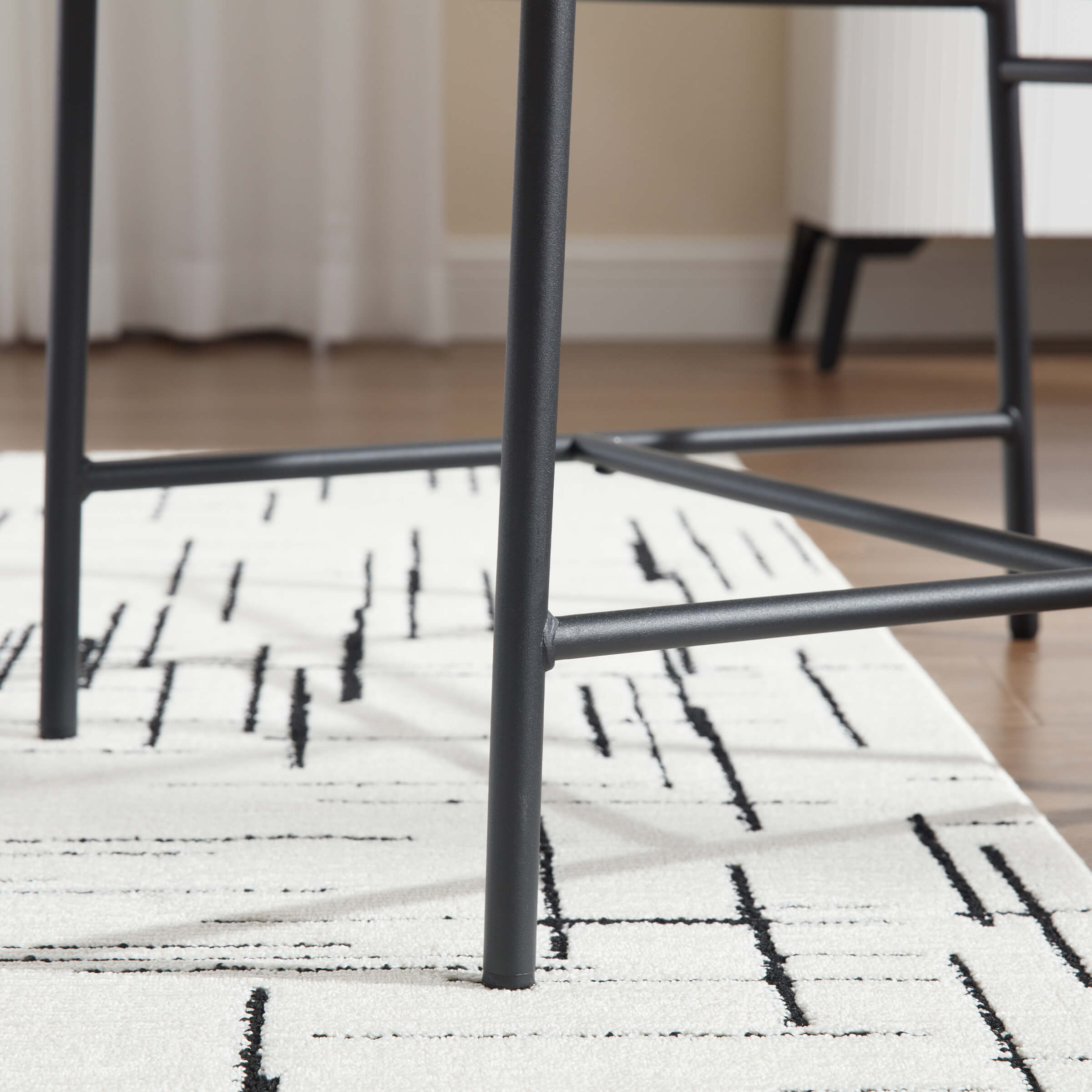 Leg and base of chair with crossbars on rug