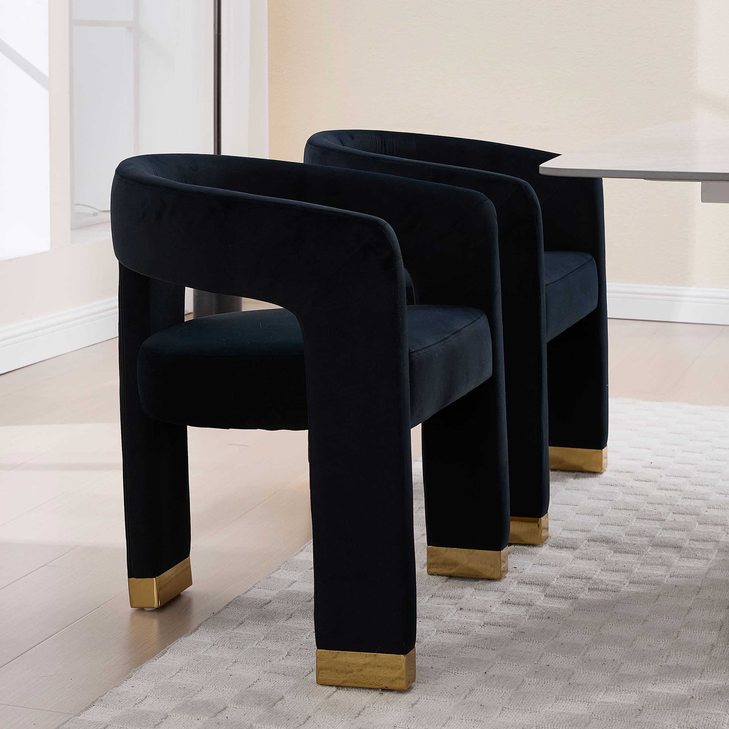 Two black velvet chairs around a table