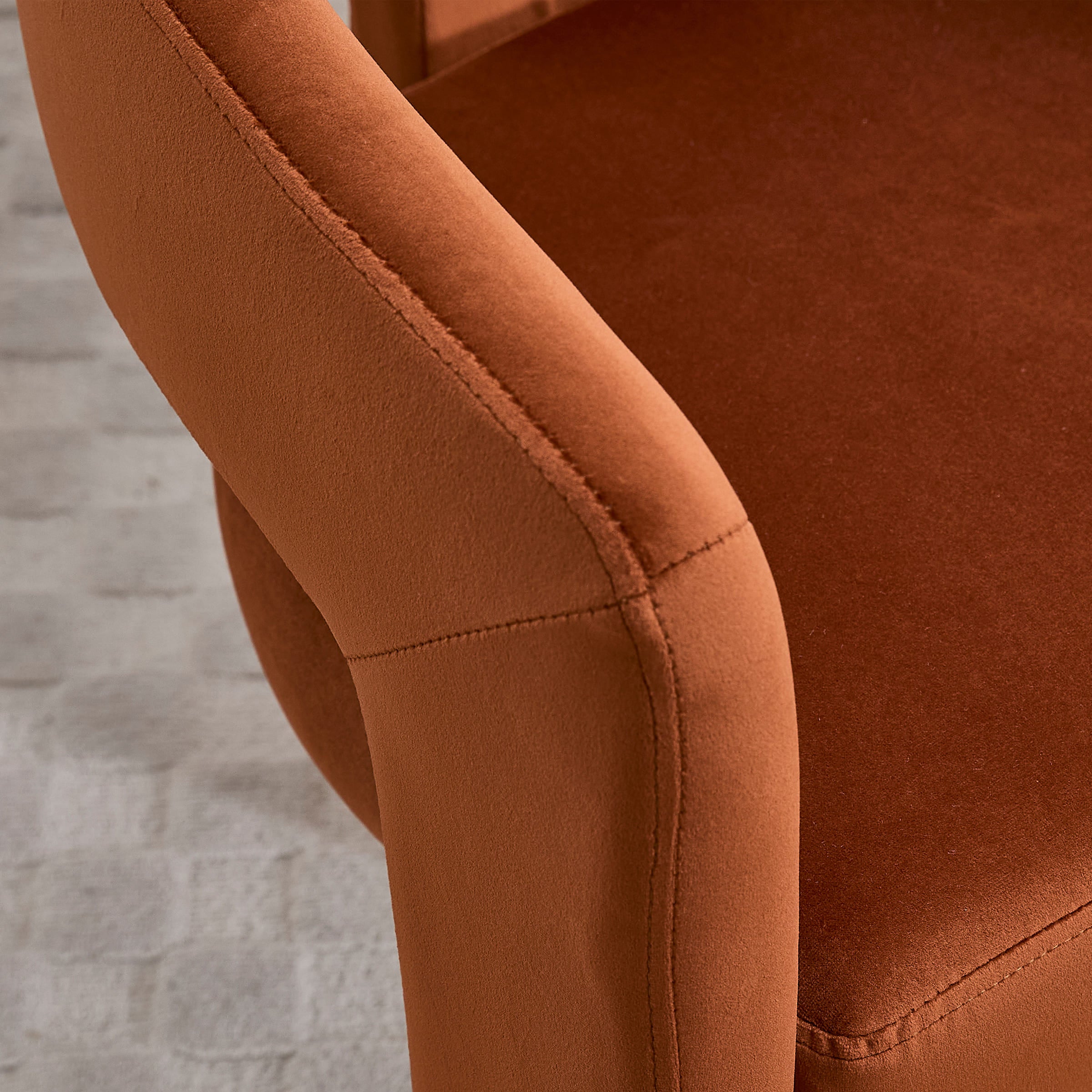 Close-up of seam on orange-brown velvet chair