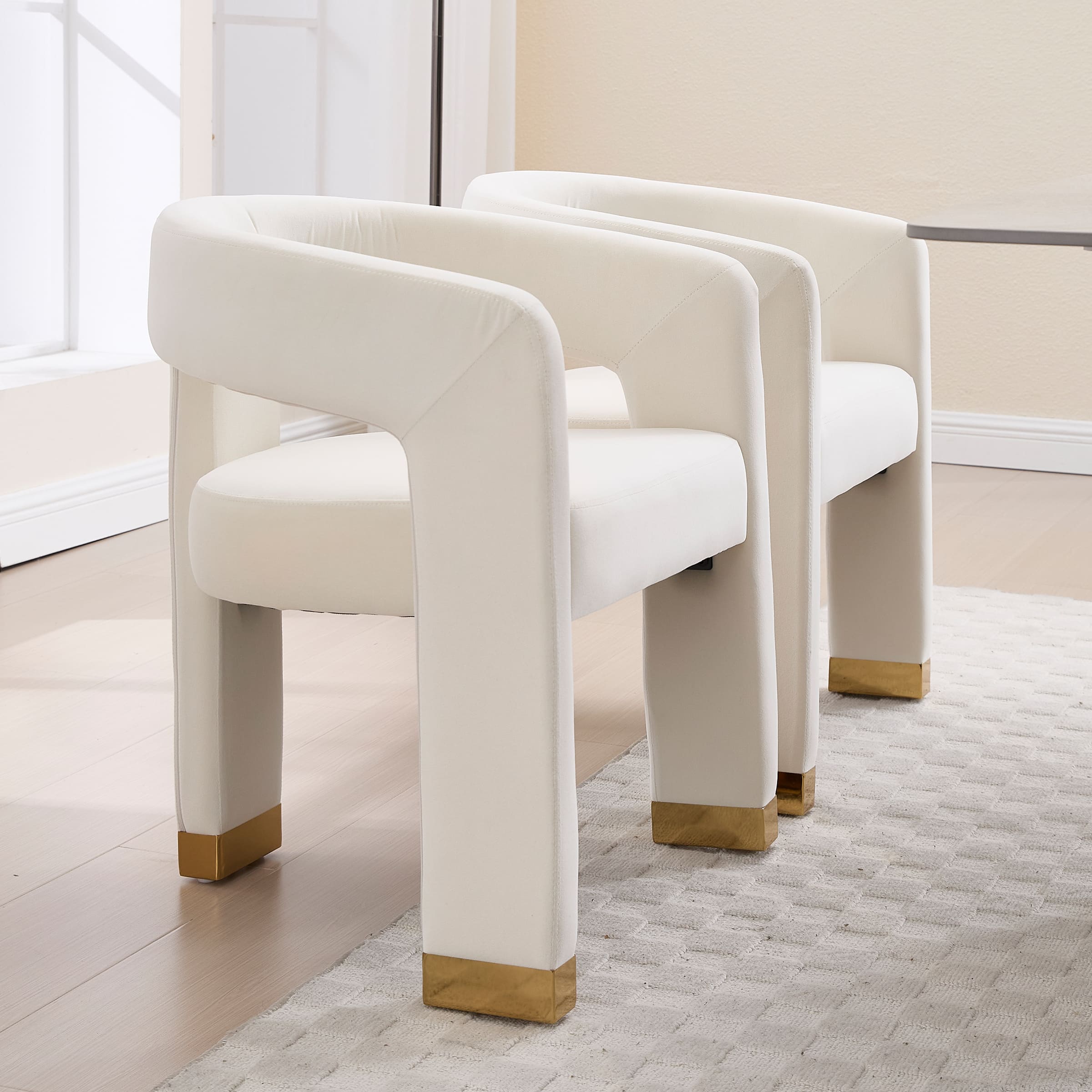 Two white velvet dining chairs viewed from the side