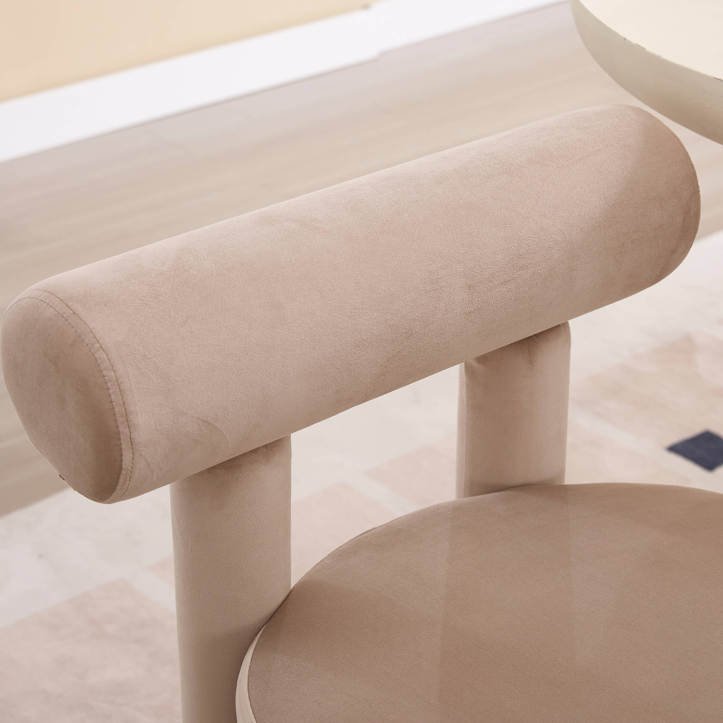 Close-up of the beige cushioned round seat and leg