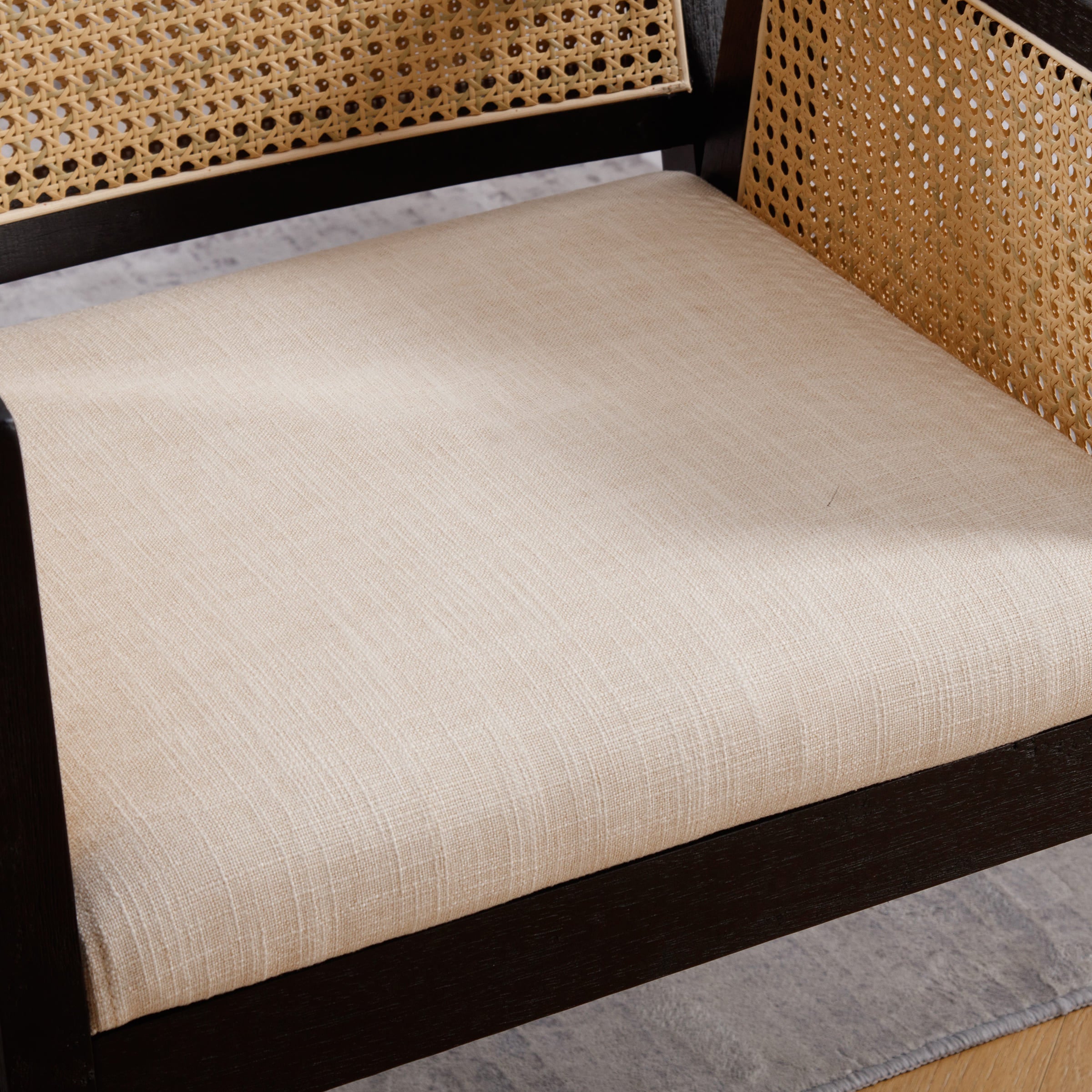 Close-up of beige seat cushion and caned side panel