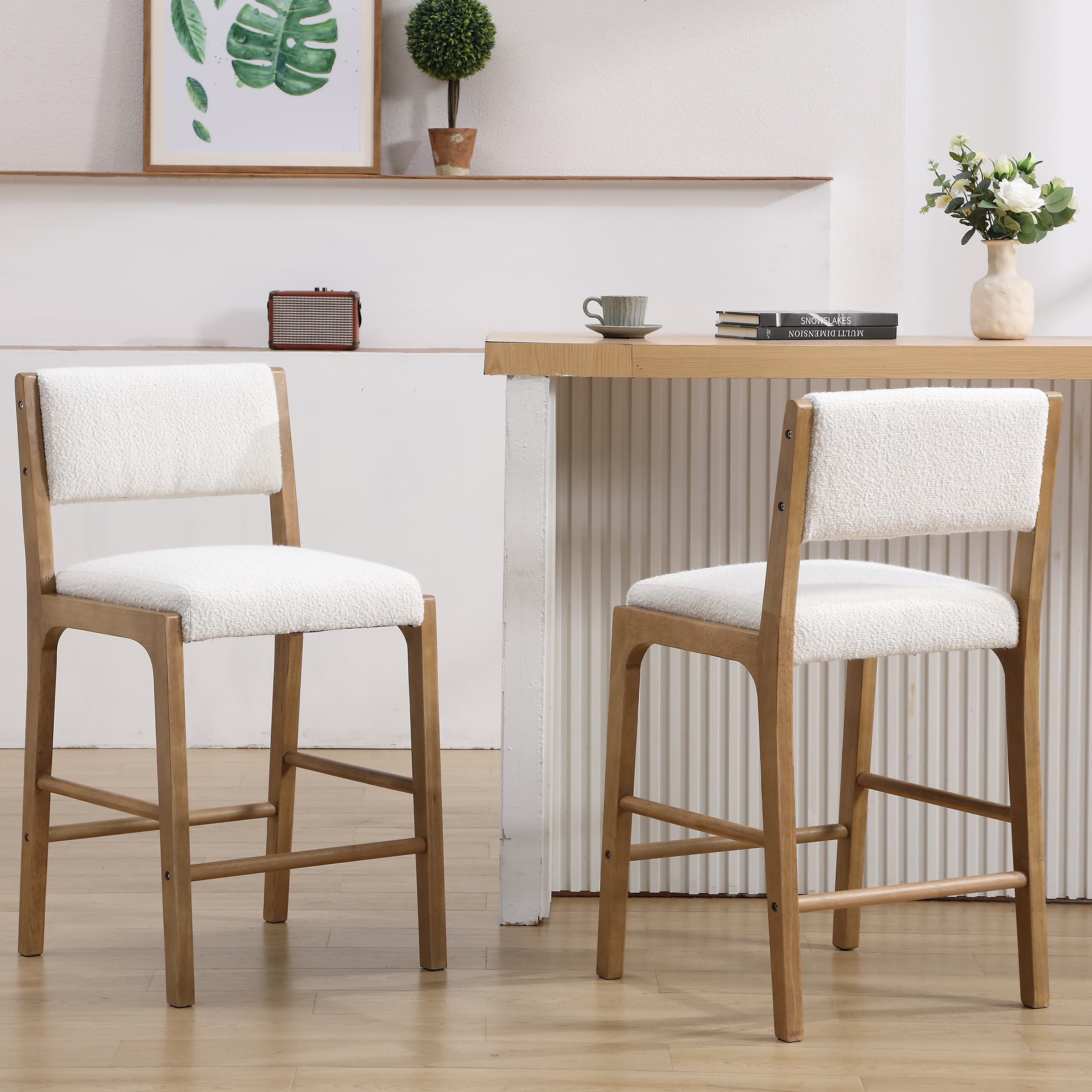 Two upholstered beige counter stools with wooden legs around a dining table