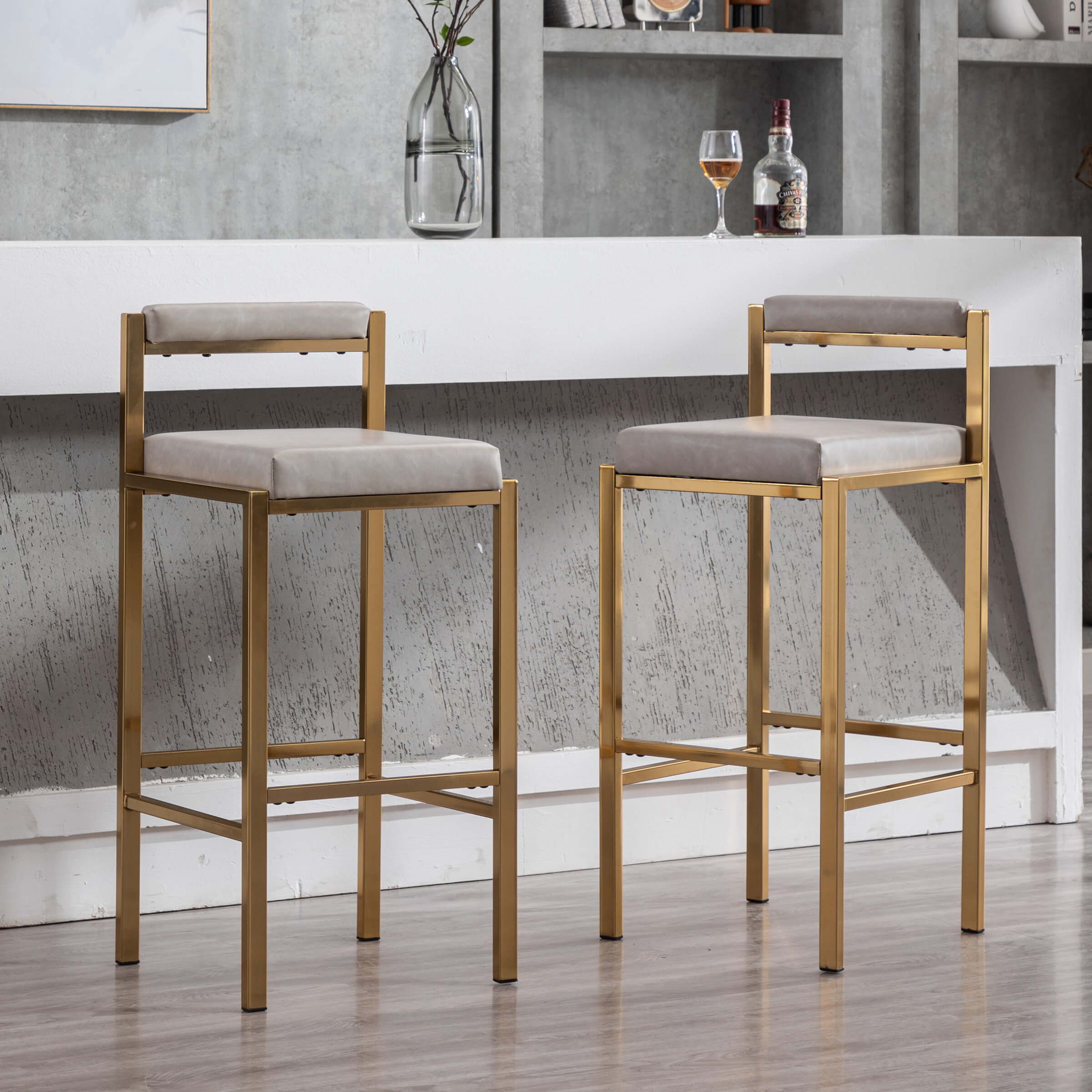 Two stools with white cushions in front of bar