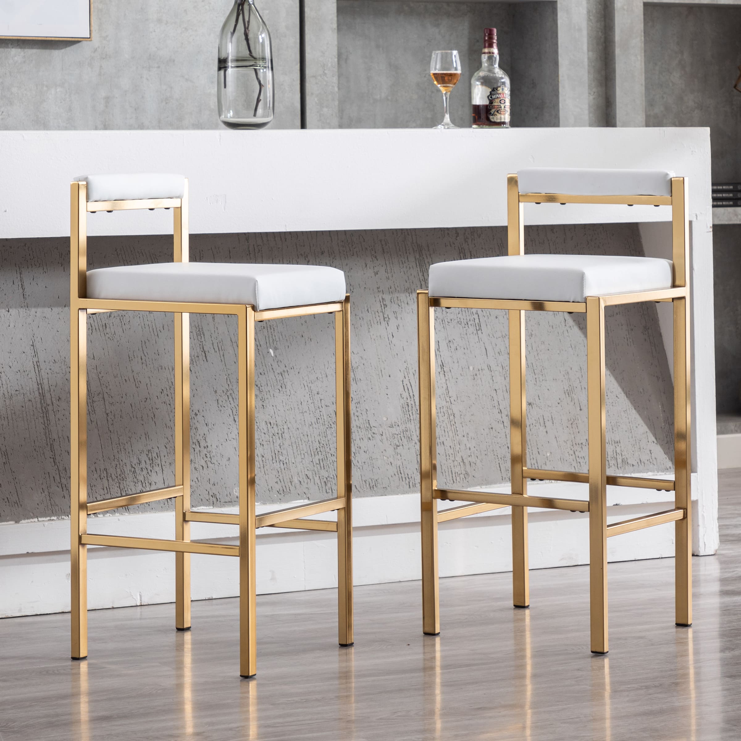 Two stools with white cushions and gold frames