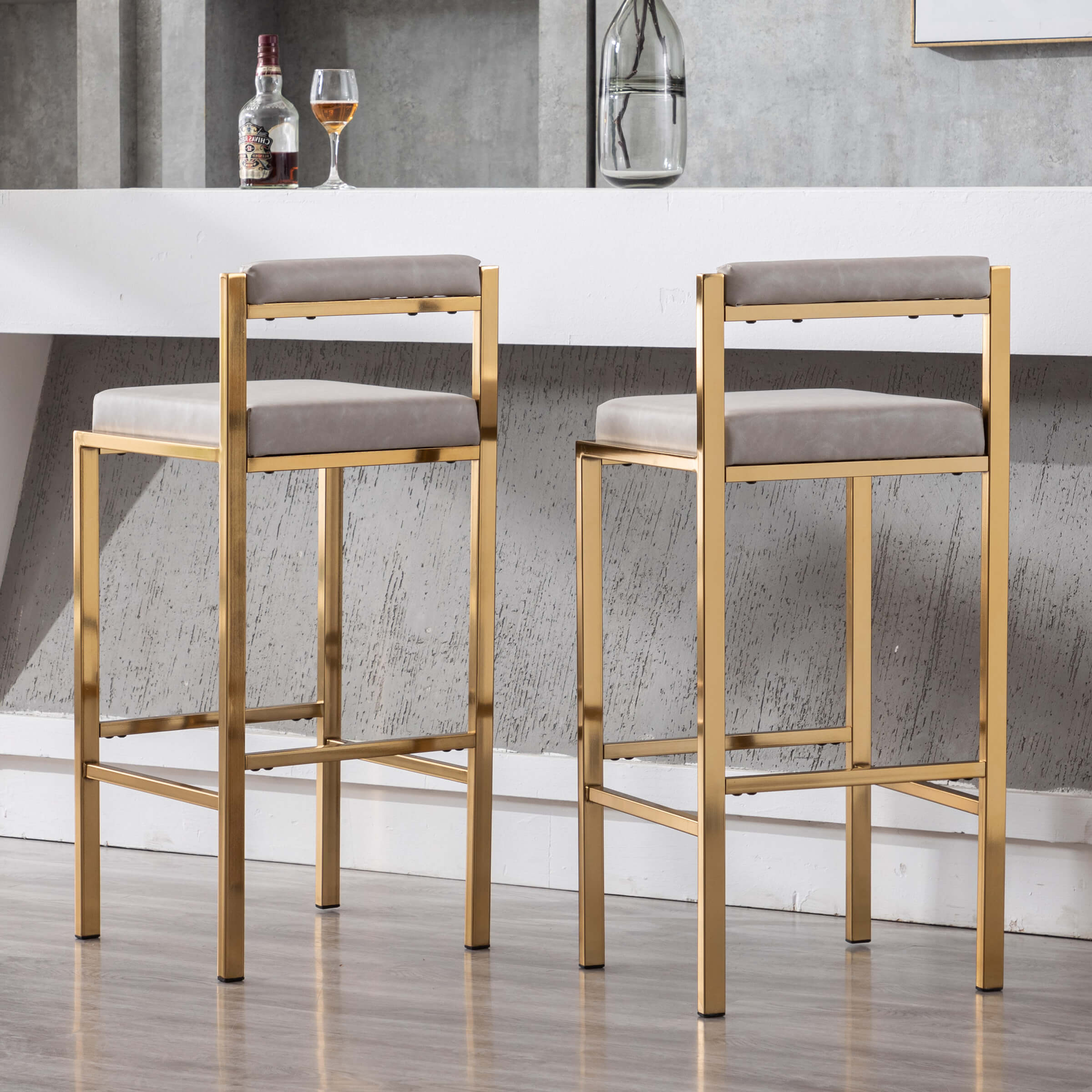 Two stools with white cushions in front of bar