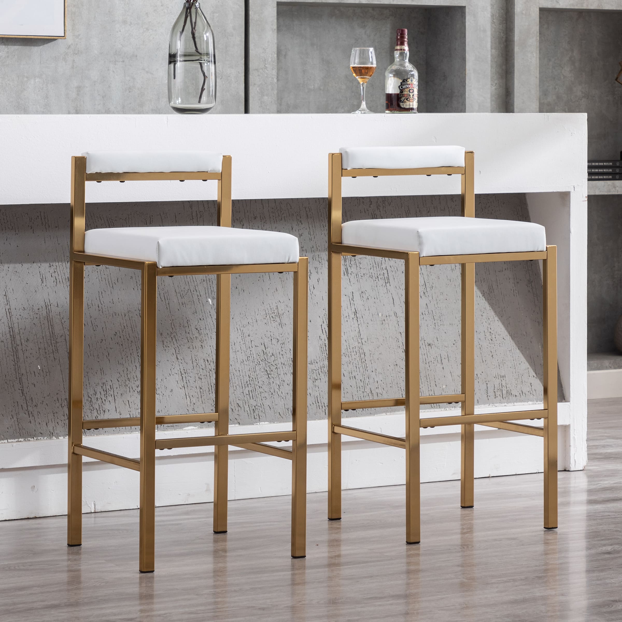 Two stools with white cushions in front of bar