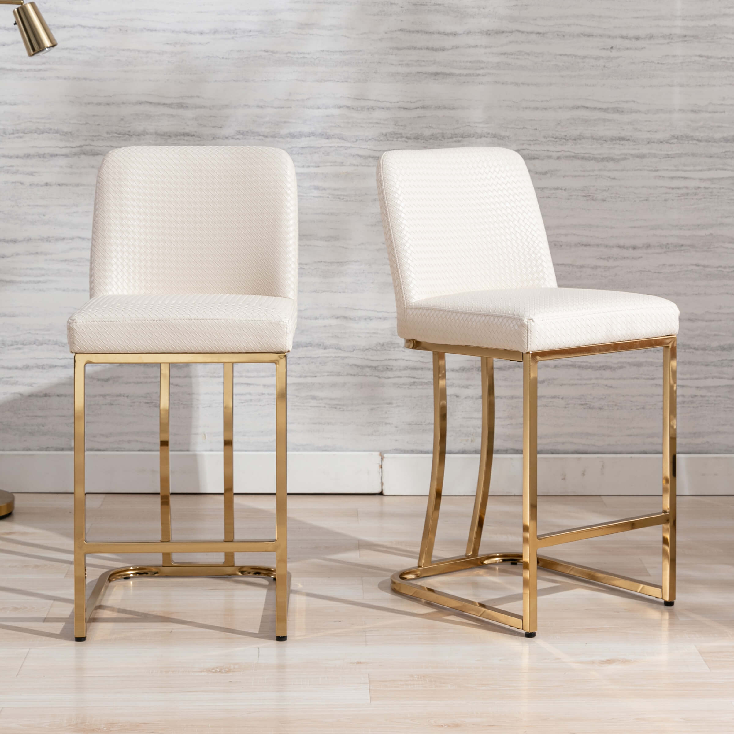 Two cream upholstered bar stools with gold frames