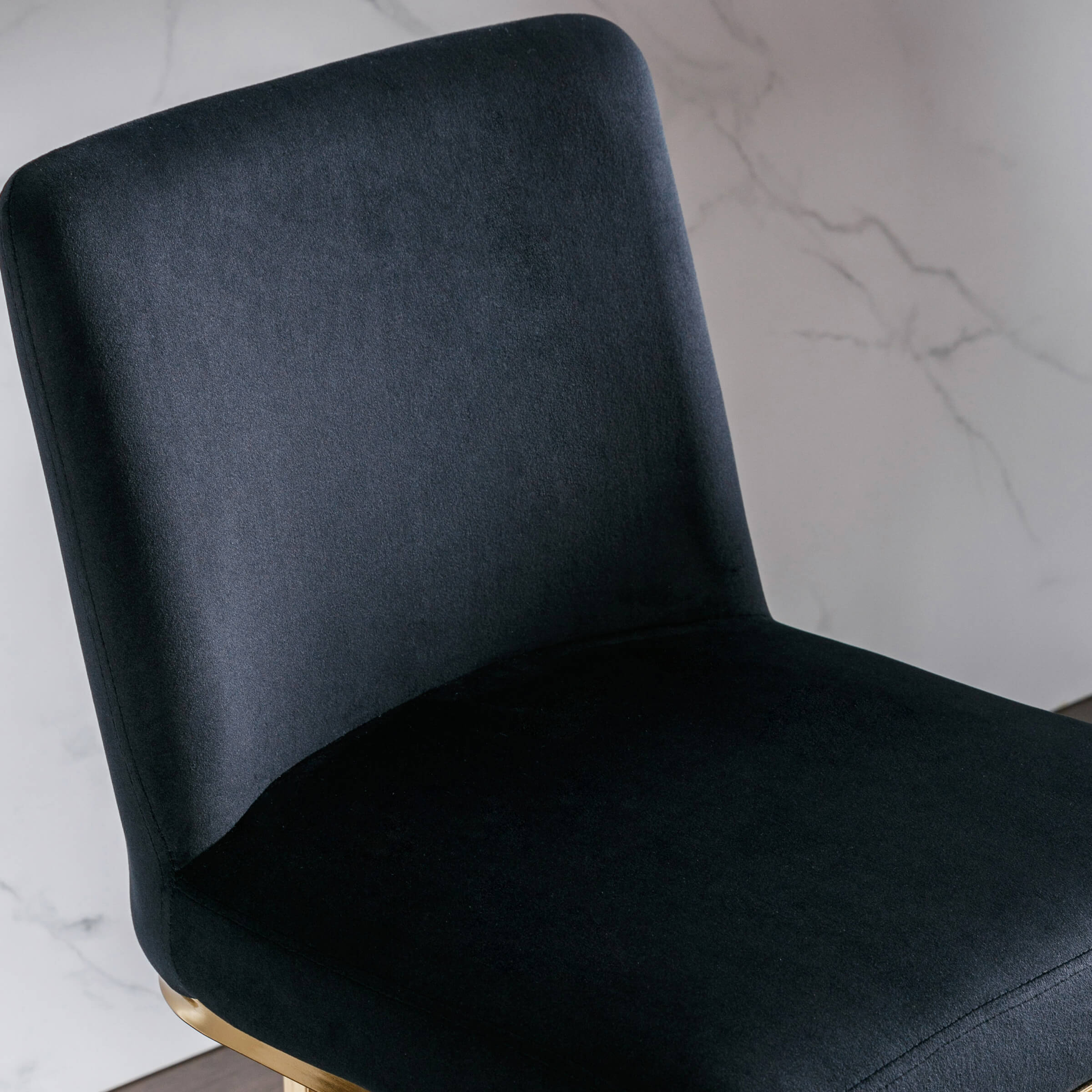 Close-up of bar stool seat and back with dark velvet upholstery