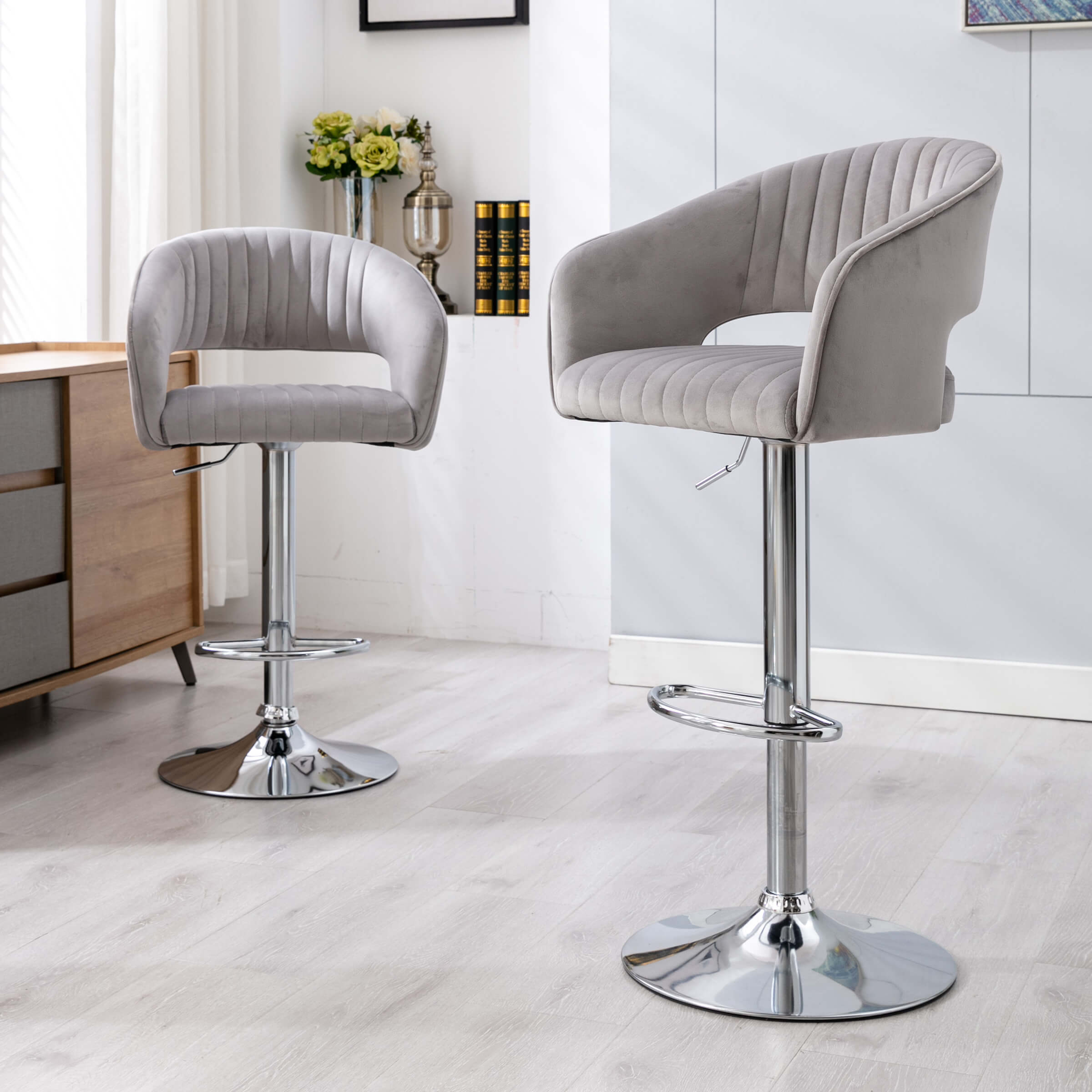 Two grey upholstered hollow-back bar stools in a modern kitchen setting