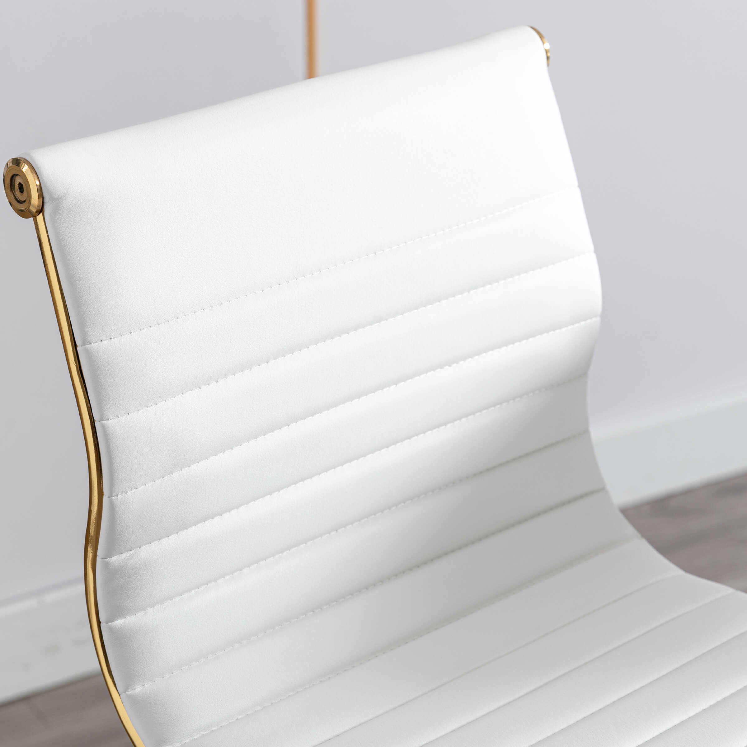 Close-up of white seat with gold frame