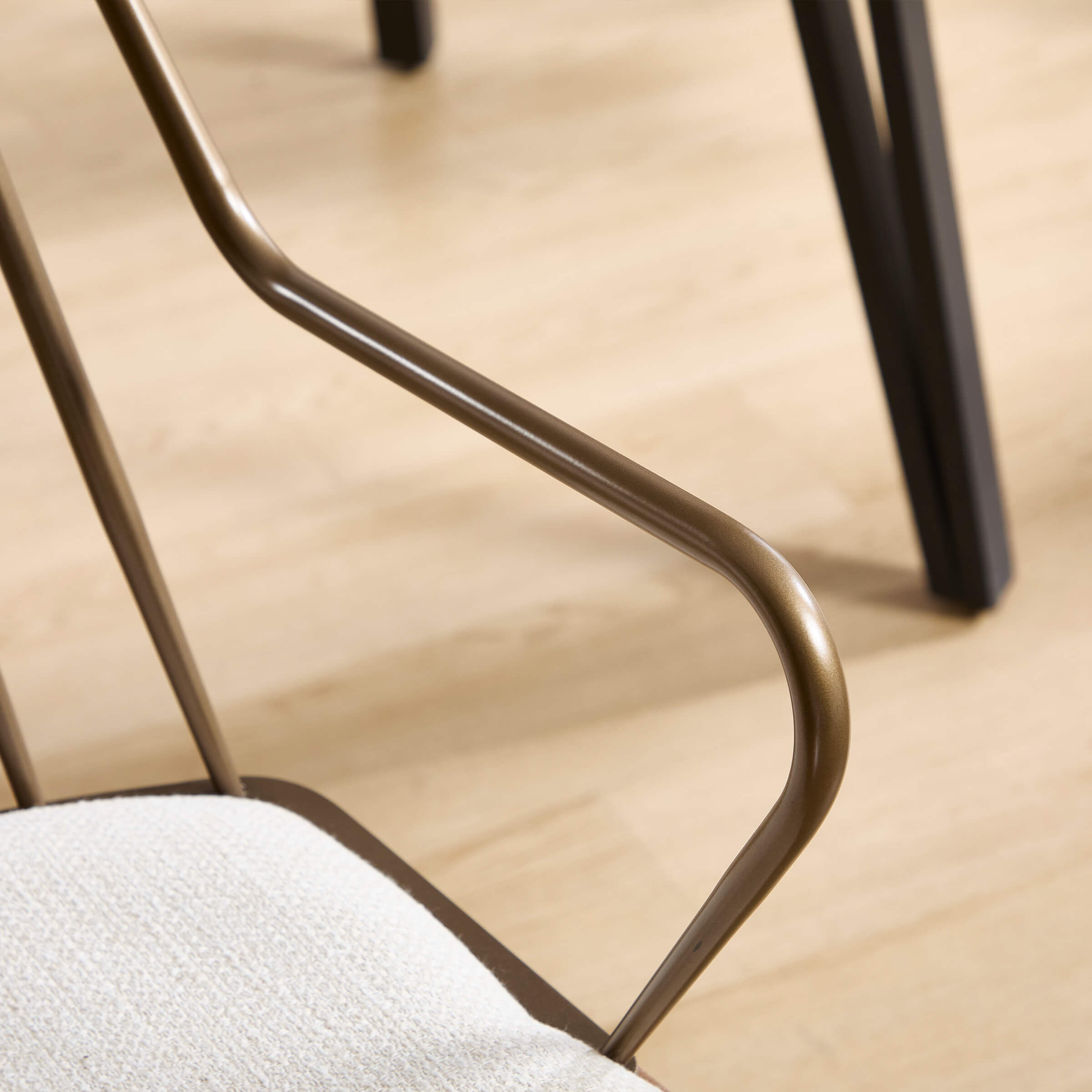 Arm of chair with slender curved metal armrest
